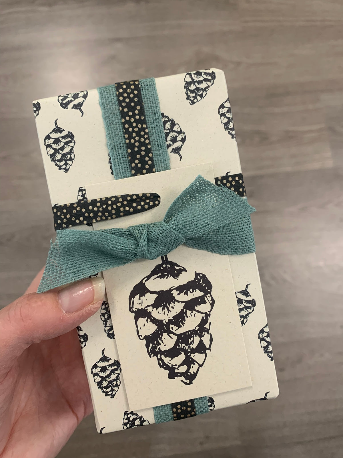 Cadeautje, ingepakt in duurzaam inpakpapier gemaakt van landbouwrestafval | Dennenappel